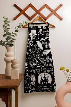 a black and white towel hanging on a wall next to a vase with flowers in it