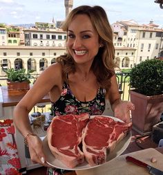 a woman holding two pieces of meat on a plate