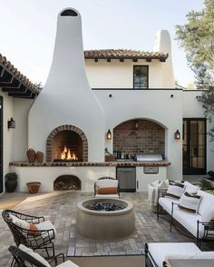 an outdoor kitchen and fireplace with seating around it