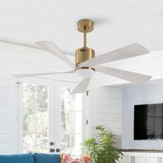 a living room with a blue couch and white ceiling fan in the middle of it