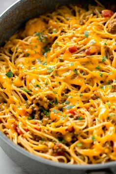 a skillet filled with spaghetti and meat in it's pan, ready to be eaten