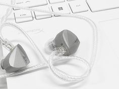 two ear buds connected to a computer keyboard