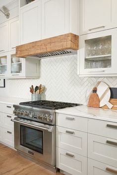 a kitchen with white cabinets and an oven