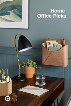 a desk with an open mailbox and office supplies on it, next to a framed painting