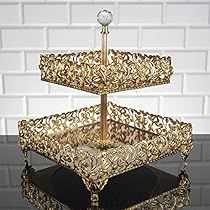 a three tiered cake stand is shown in front of a white brick wall and black floor