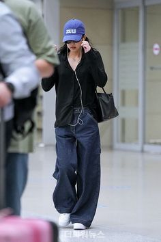 a woman walking through an airport talking on her cell phone