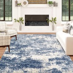 a living room filled with furniture and a blue rug on top of a hard wood floor