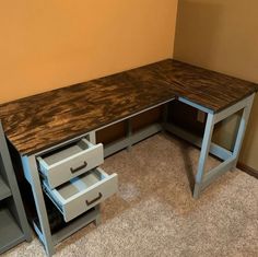 a corner desk with drawers in an empty room next to a wall and carpeted floor