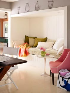 a living room filled with lots of furniture next to a dining room table and chairs