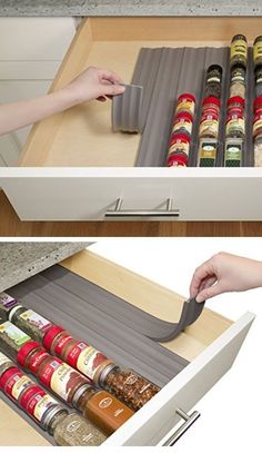 an open drawer with spices in it and someone reaching for the spice bottle on the bottom