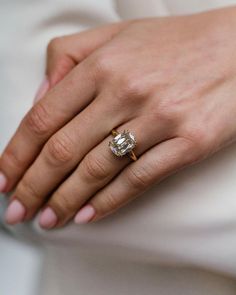 a close up of a person wearing a ring on their finger with a diamond in the middle