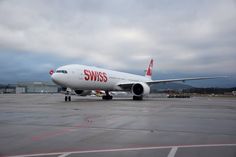 an airplane is sitting on the tarmac with cloudy skies in the backgroud