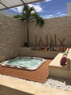 an outdoor jacuzzi is shown in the middle of a patio with seating and pillows