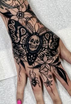 a woman's hand with a tattoo on it and a skull in the middle