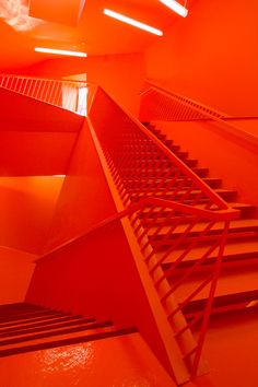 an orange room with stairs leading up to the ceiling