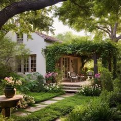 a white house surrounded by greenery and flowers