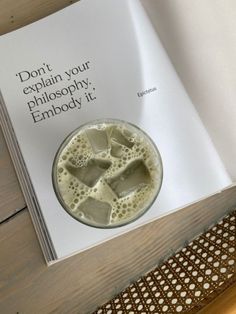 a book with an image of a drink in it on top of a wooden table