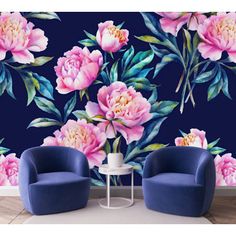 two blue chairs in front of a wall with pink flowers on it