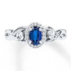 an oval blue sapphire and diamond ring with three diamonds around the band, set in 18k white gold