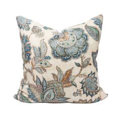 a blue and white pillow with an intricate floral design on the front, sitting on a white background