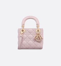 The Lady Dior bag epitomizes the House's vision of elegance and beauty. Sleek and refined, the timeless style is crafted in pale pink lambskin with Cannage stitching, creating the unmistakable quilted texture. Pale pink enamel D.I.O.R. charms complement the new removable chain strap with alternating pale gold-finish metal and pastel enamel O-links. The miniature Lady Dior bag can be carried by hand or worn crossbody as an ideal evening companion.. Mini Lady Dior, Lady Dior Handbag, Dior Star, Icon Shoes, Dior Book Tote, Small Lady, Christian Dior Couture, Dior Handbags, Backpack Tote Bag