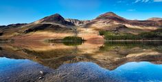 the mountains are reflected in the still water