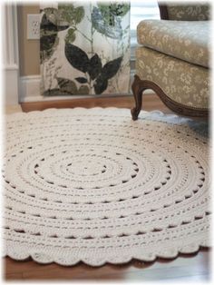 a crocheted rug on the floor in front of a chair