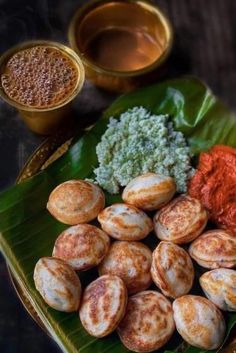 some food is on a green plate with sauces and seasoning next to it