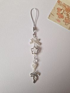 a pair of earrings with charms hanging from it's hooks on a white wall