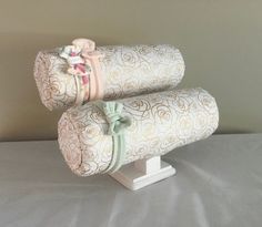 two rolled up baby blankets sitting on top of a white stand