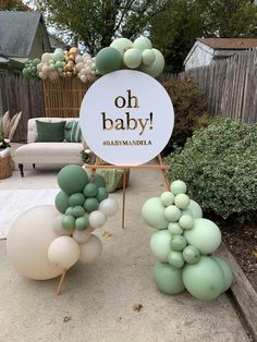 some balloons that are sitting on the ground in front of a sign saying oh baby