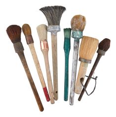 an assortment of different types of brushes on a white background