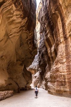 a man is walking through the narrow canyon