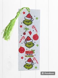 Bookish Grinch Bookmark.  Perfect gift for book lovers, book clubs, teachers, stocking stuffers, etc.!  My acrylic bookmark is designed by me and can be made with a holographic finish or plain finish.  Please make notation in personalization section at checkout.  If no notation is written, the bookmark will be delivered with a holographic finish.   It measures approximately 5" x 2" and comes with matching tassel.  Tassel shown may not be tassel sent according to availability.  Image is made with waterproof vinyl laminate and is printed on one side but can be made on both sides. Grinch Bookmarks, Christmas Book Marks, Candy Cane Bookmark, Penguin Bookmark, Groovy Bookmarks, Bookclub Gifts, Watercolor Bookmarks, Gifts For Readers, Secret Santa