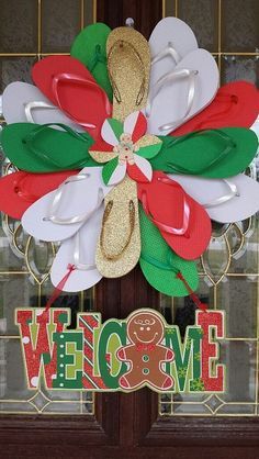 a wreath with flip flops and a gingerbread door hanger on a front door