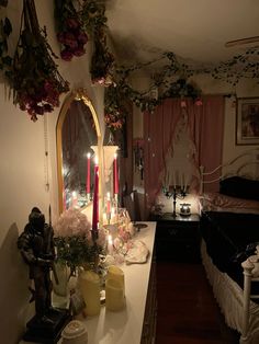 a room with flowers and candles on the counter next to a bed, mirror and other decorations