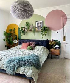 a bedroom decorated in shades of green, pink and yellow with plants on the wall