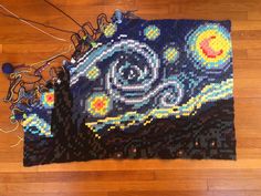 a piece of art made out of beads and string on the floor with strings attached to it