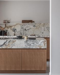 a kitchen with marble counter tops and wooden cabinets