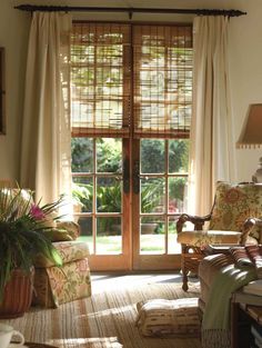 a living room with two chairs and a door leading to a patio area that has sliding glass doors