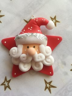 a red and white christmas ornament with a santa clause on it's face