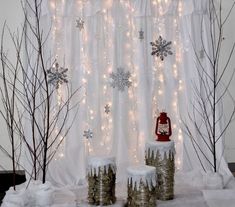 christmas decorations are displayed in front of a window with snowflakes and lights on it