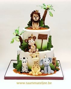 a three tiered cake decorated with animals and palm trees