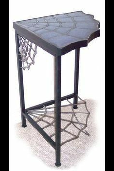 a metal table with an intricate design on it's top and bottom shelf,