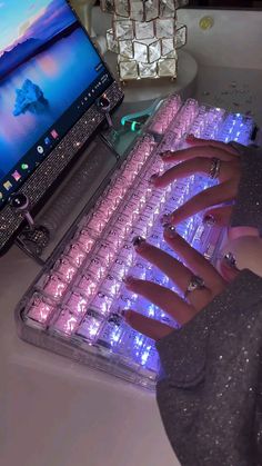 a woman's hand is on the keyboard of a computer that has glowing lights