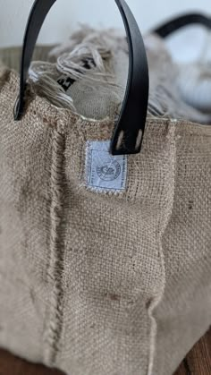 a brown bag with a black handle sitting on top of a wooden table