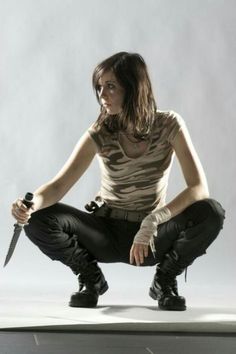 a woman kneeling down with a knife in her hand