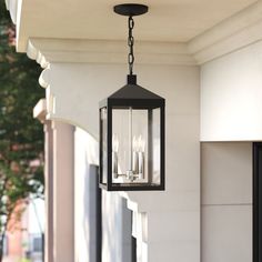 an outdoor light hanging from the side of a building