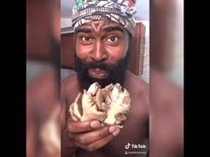 a man with a turban is holding up a piece of food to his face