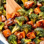 broccoli and tofu stir fry in a pan with a wooden spoon